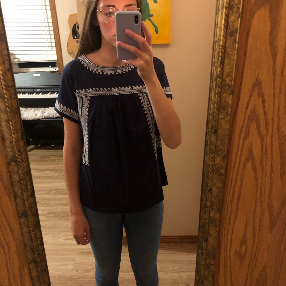 Navy blouse with white details.